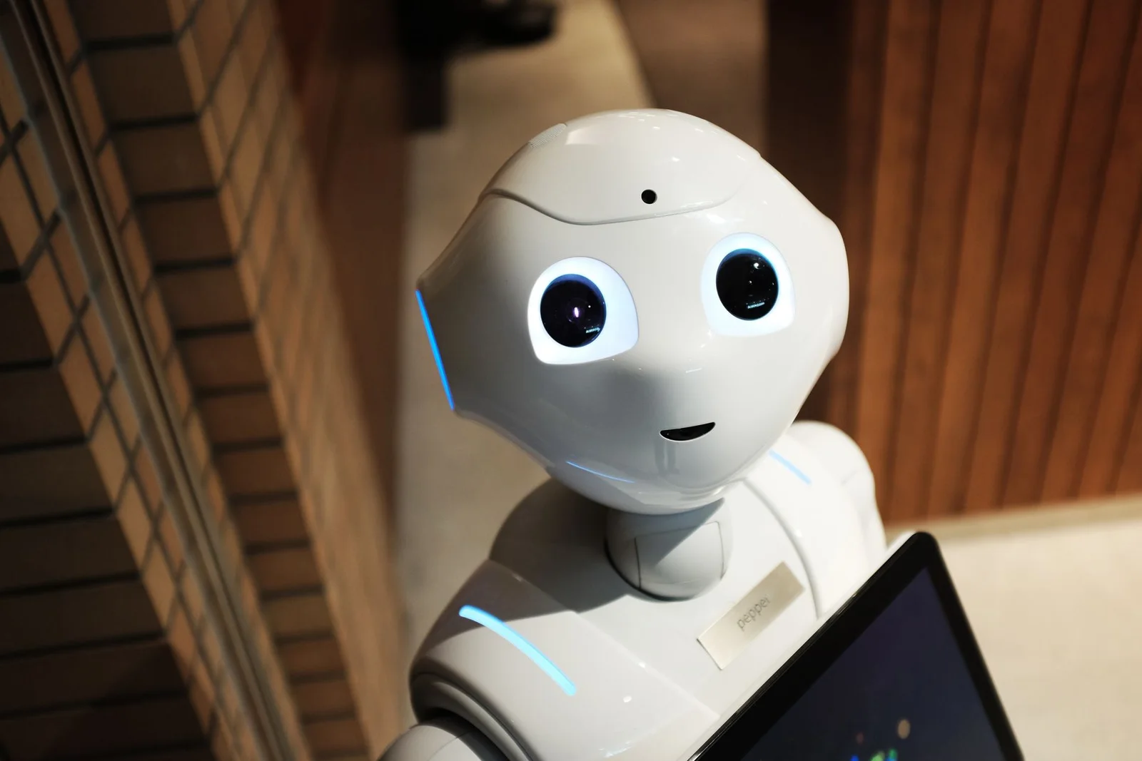 Robô humanoid branco em ambiente interno, representando a nova geração de robôs treinados com dados humanos